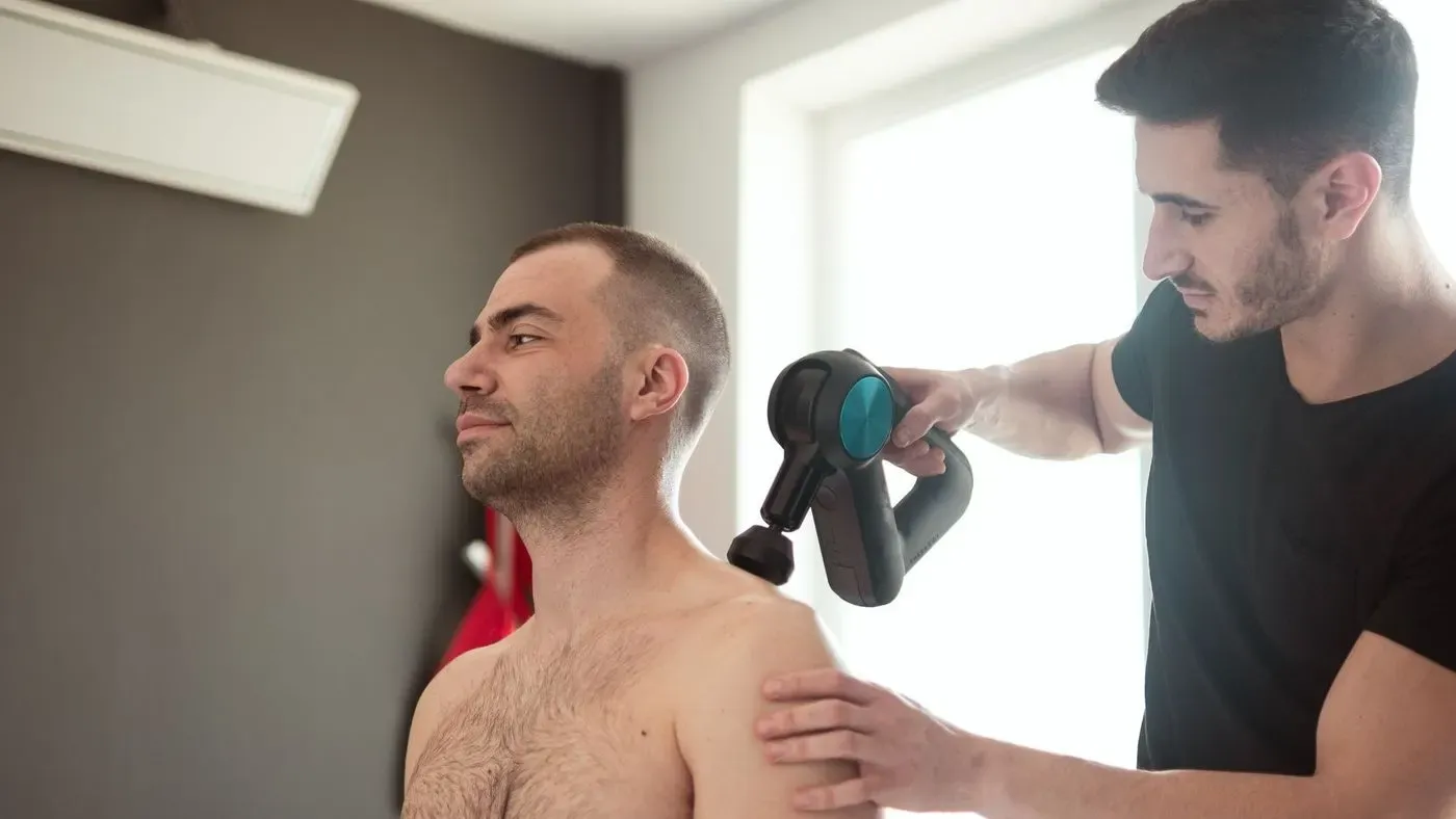 Massagepistol som ligger på ett bord