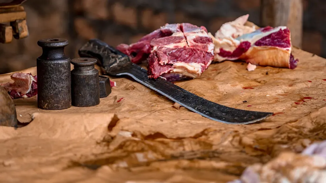 Person som mal kött i köket