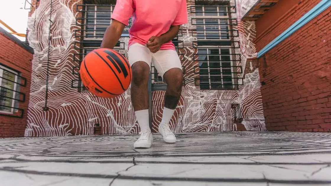Person spelar basket på plan