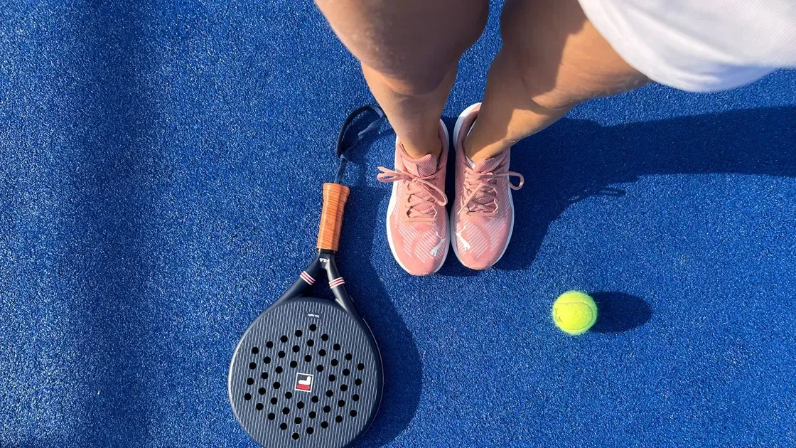Person som bär padelväska på bana