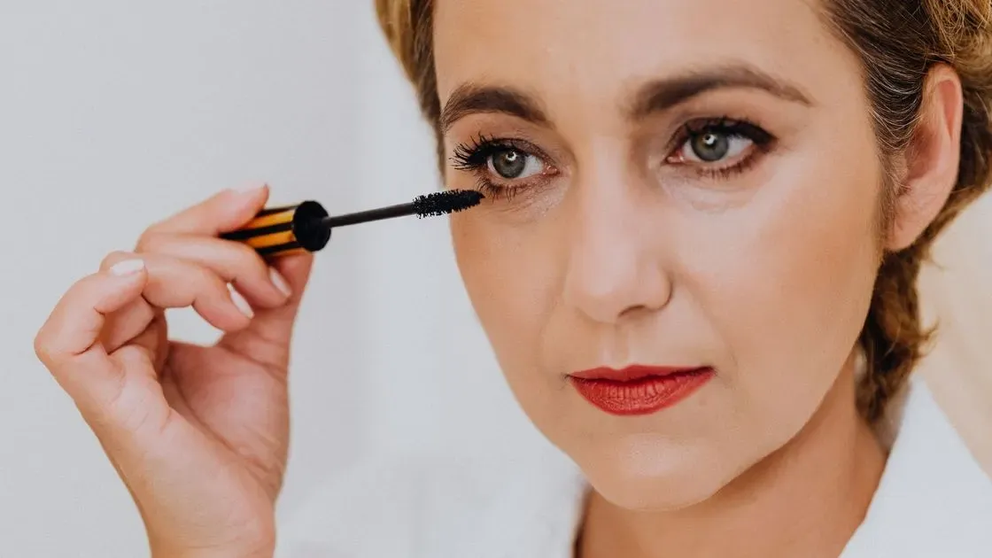 Kvinna som applicerar mascara på ögonfransar