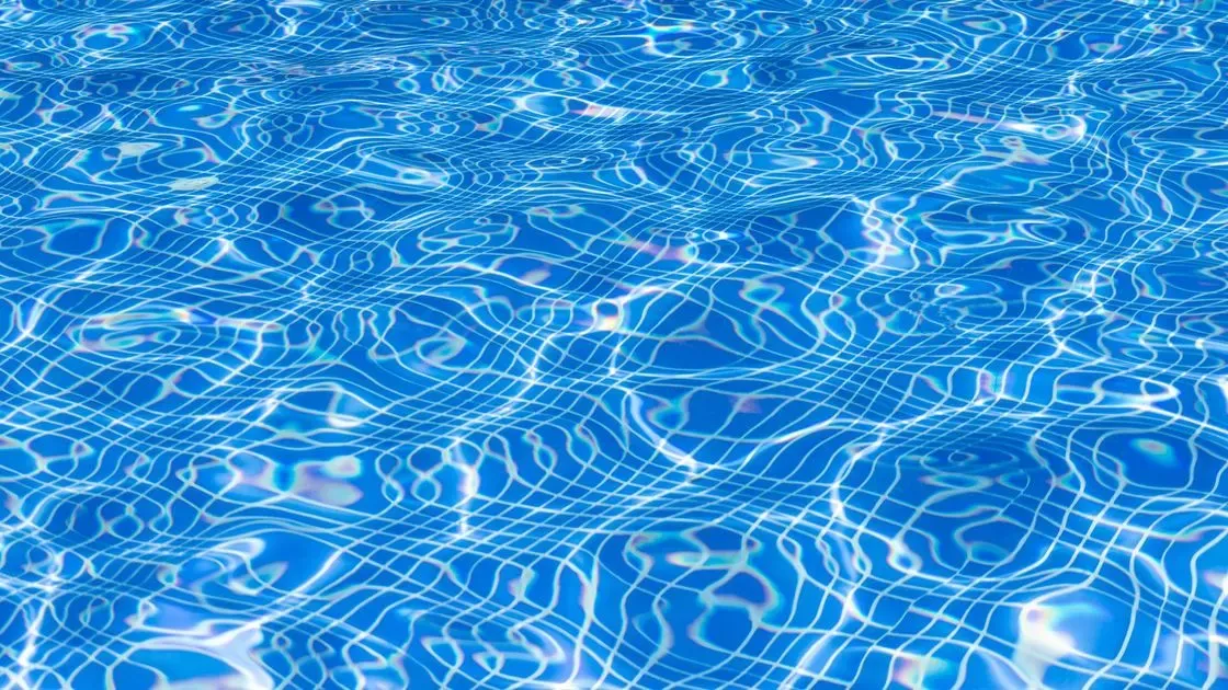 Person testar poolvattnets kvalitet